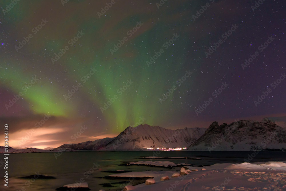 L'aurora boreale disegna strisce verdi nel cielo nella notte delle Isole Lofoten