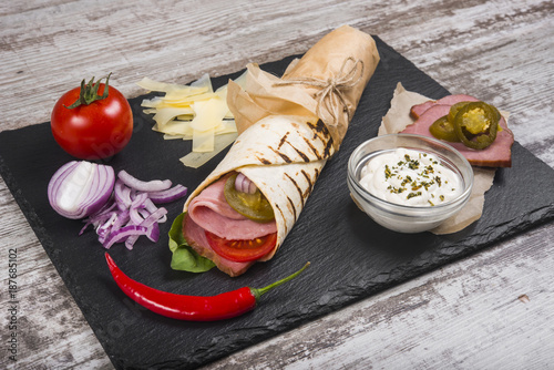 Burito with ham, tomatoes and jalapeno pepper.