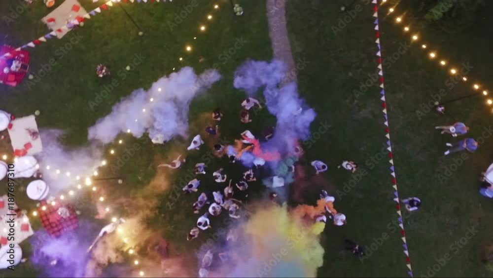 Happy friends making wedding party,throwing confetti and using colorful smoke bombs at party outdoor - Young people having fun together. Aerial. Ukraine, Kiev, 20.08.2016