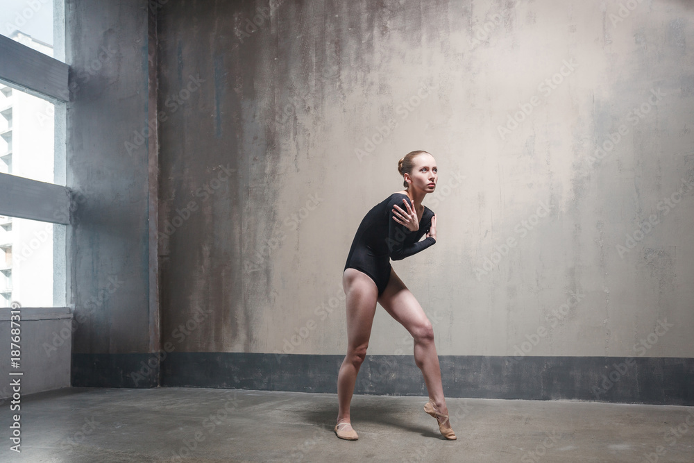 The ballerina has frozen and embraces herself in a cold hall