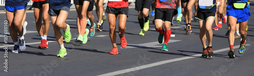 marathon runners legs running on city road © lzf