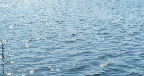 Water surface with waves glittering in the sun