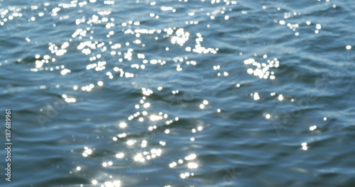 Defocused shot of a wavy water surface with a beautiful bokeh of sun glares