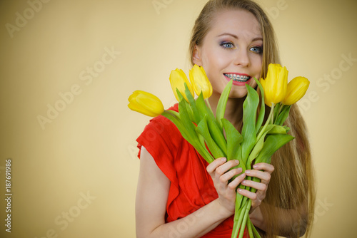 Pretty woman with yellow tulips bunch