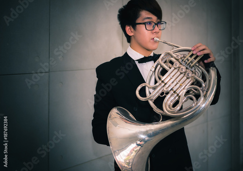 Musicain playing instrument horn in the hall