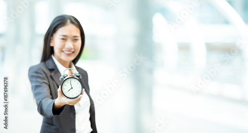 Business womwn holding a clock on her hands