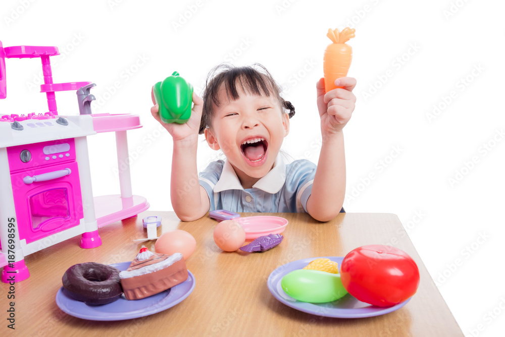Little asian girl playing with kitchen toy over white background Little asian girl playing with kitchen toy over white background