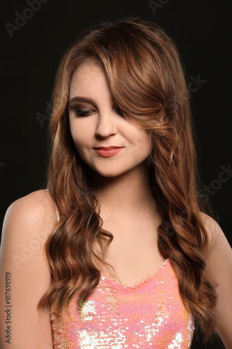 Attractive young woman with caramel highlights on black background