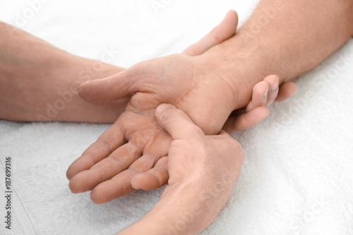 Physiotherapist giving hand massage to senior patient, closeup