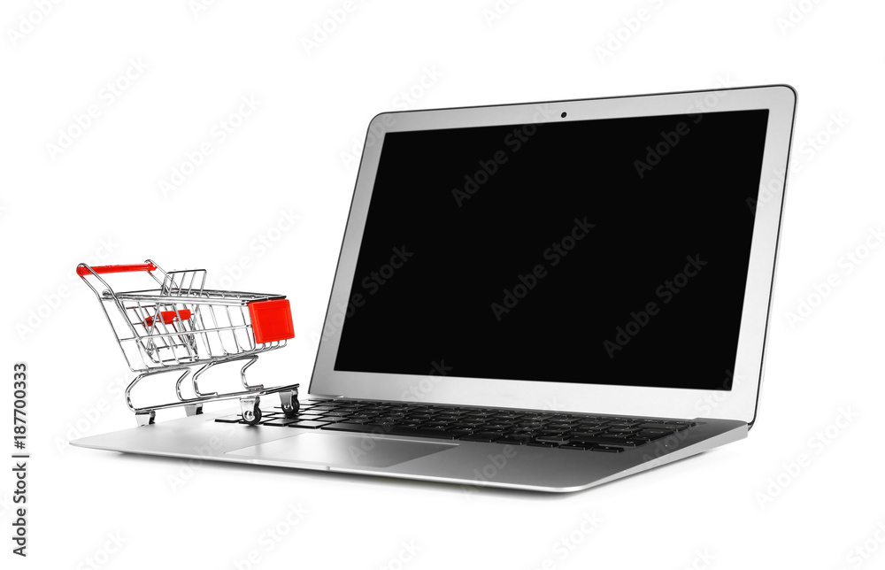 Laptop with mini market trolley, isolated on white. Internet shopping concept