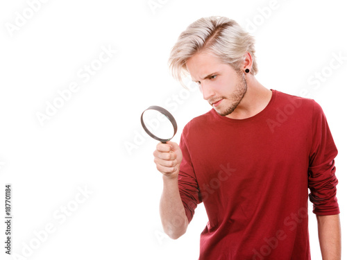 man holds on eye magnifying glass looking through loupe