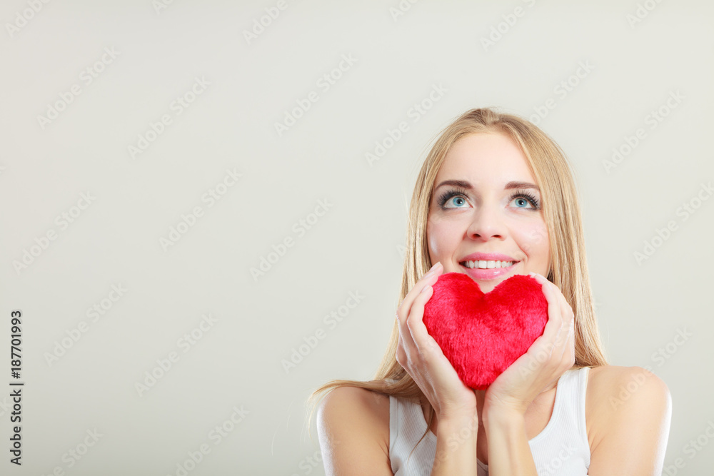 Smiling woman holding red heart love symbol Smiling woman holding red heart love symbol