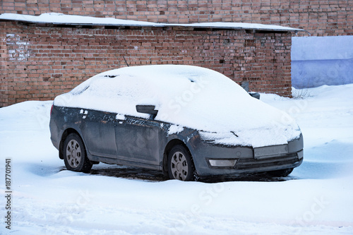 Parked cars covered with snow.