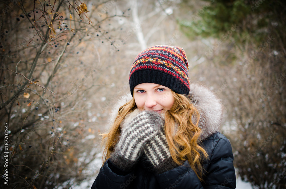 Girl in warm clothes in the winter forest