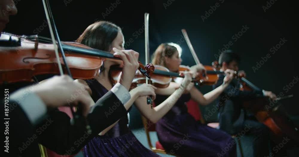 string quartet performs on stage, close-up of violin in work