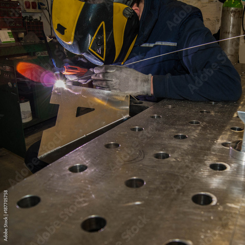 man in concentrate on welding tig mode an aluminium letter photo