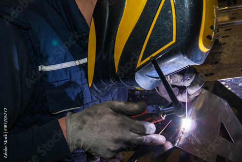 man in concentrate on welding tig mode an aluminium letter