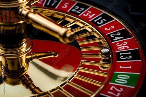 Lucky thirteen and casino gambling concept with a closeup on a section of the of roulette wheel with the ball in the winning number 13 black photo