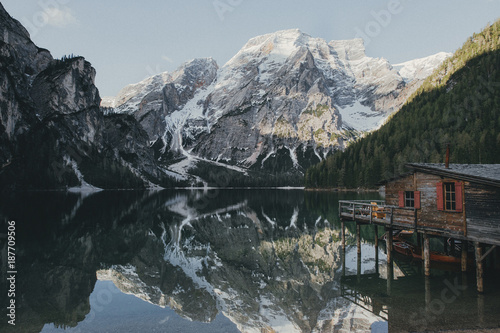 Young couple in love on the pier at lake  lago di braies Dolomite Italy. Man and woman on vacation in beautiful place.