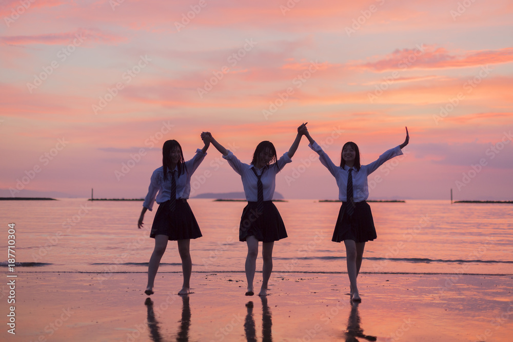 Fototapeta premium 夕焼けの海と女子高生
