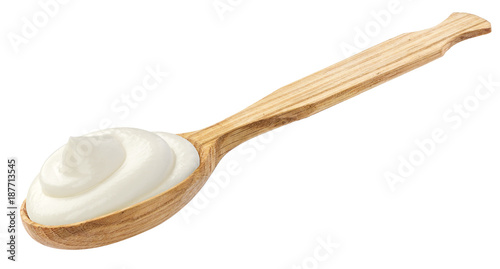 Sour cream in wooden spoon isolated on white background