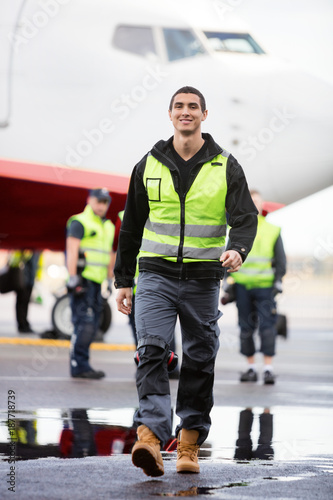 Young Male Worker Walking On Wet Runway At Airport