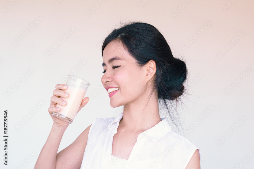 Head Shot portrait of Young Asian woman holding a glass of milk Head Shot portrait of Young Asian woman holding a glass of milk