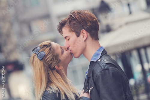Cute young couple posing outdoors on the street.