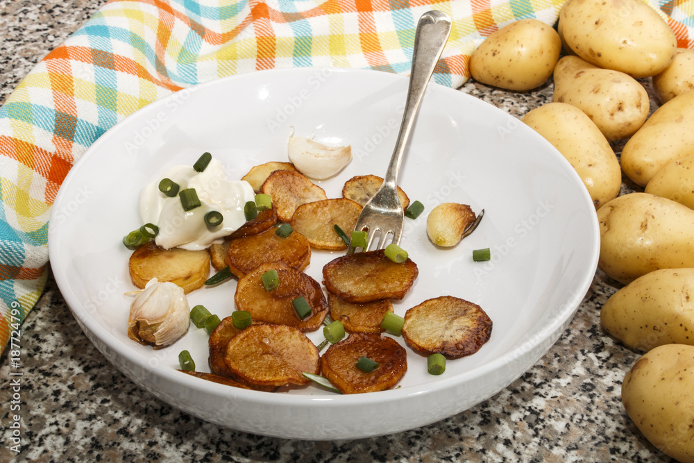 fried potatoes, served with sour cream, roasted garlic and spring onions