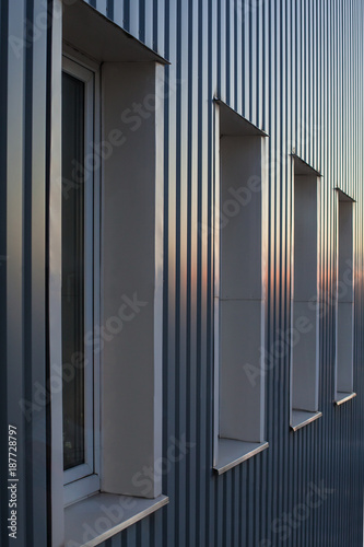 Abstract perspective of plastic windows on a metal covered wall, rainbow gradient colored by a sunset light © Marija