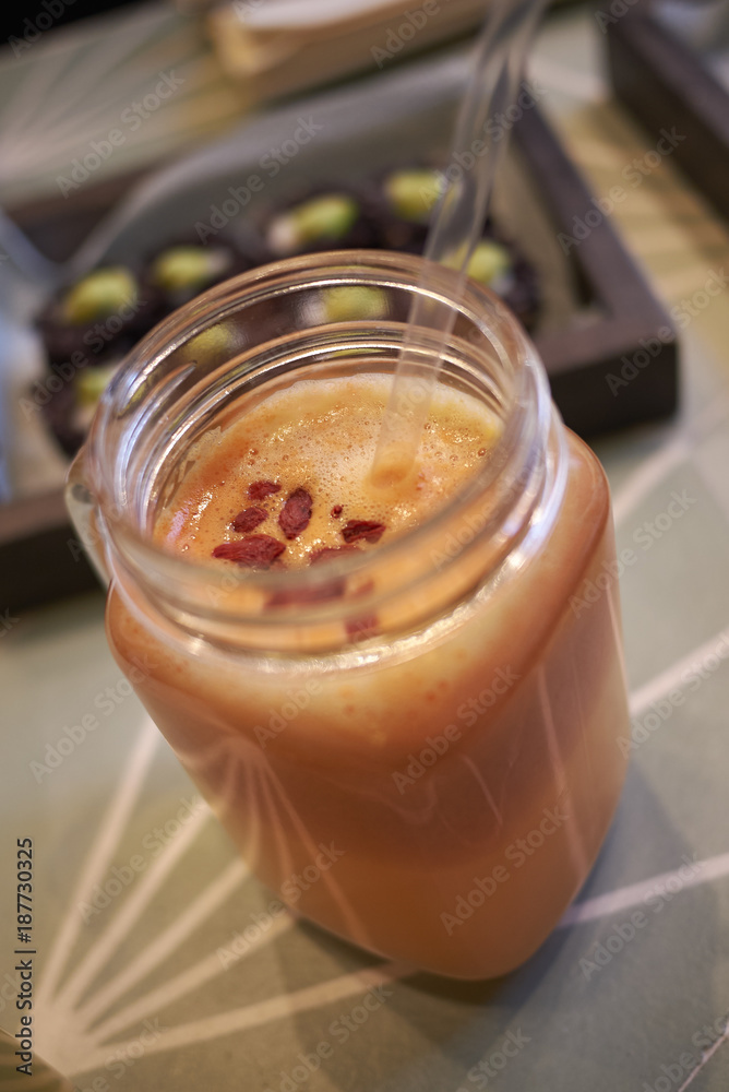 Milan, Italy - December 17, 2017 : Orange smoothie with goji berries Milan, Italy - December 17, 2017 : Orange smoothie with goji berries