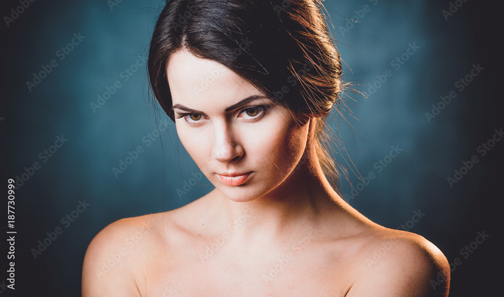 Fototapeta premium Beautiful, young and emotional girl in studio, on a dark background
