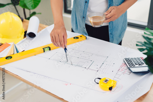 architect working and sketching architectural drawing plan on table in office