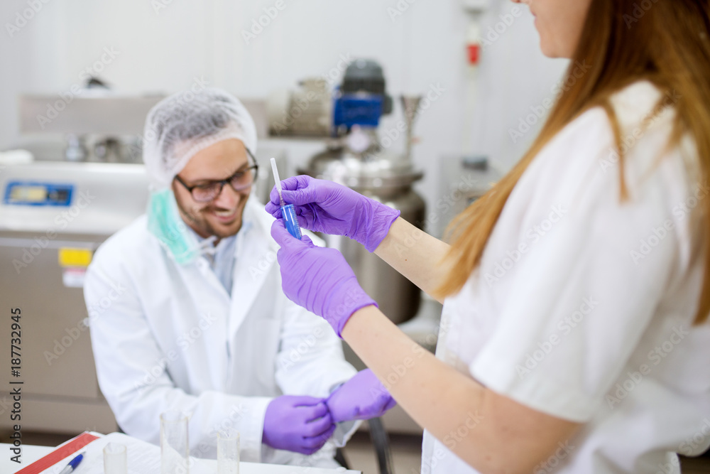 Close up of two scientists checking the quality of water in the laboratory. Close up of two scientists checking the quality of water in the laboratory.