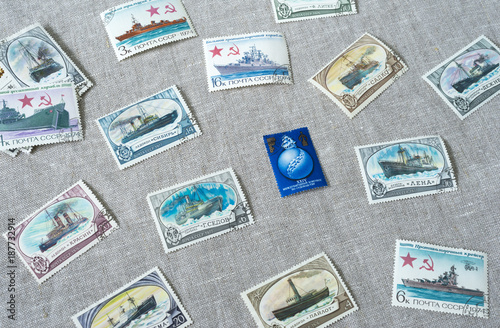 The thematic postage stamps with ships are on the desk. It is a pile of postmark. photo
