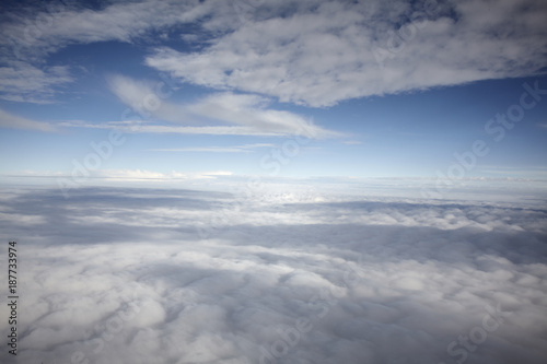 flying high in a blue sky with white clouds and sun shine