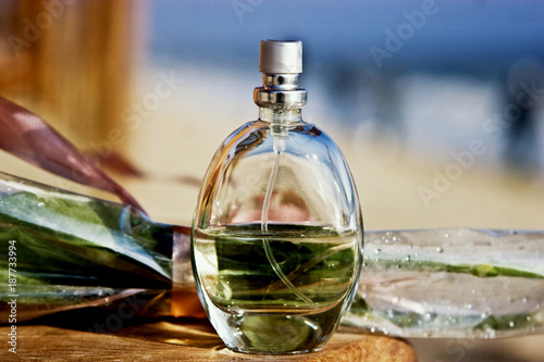 A bottle of perfume with a bouquet of roses on the background of the sea