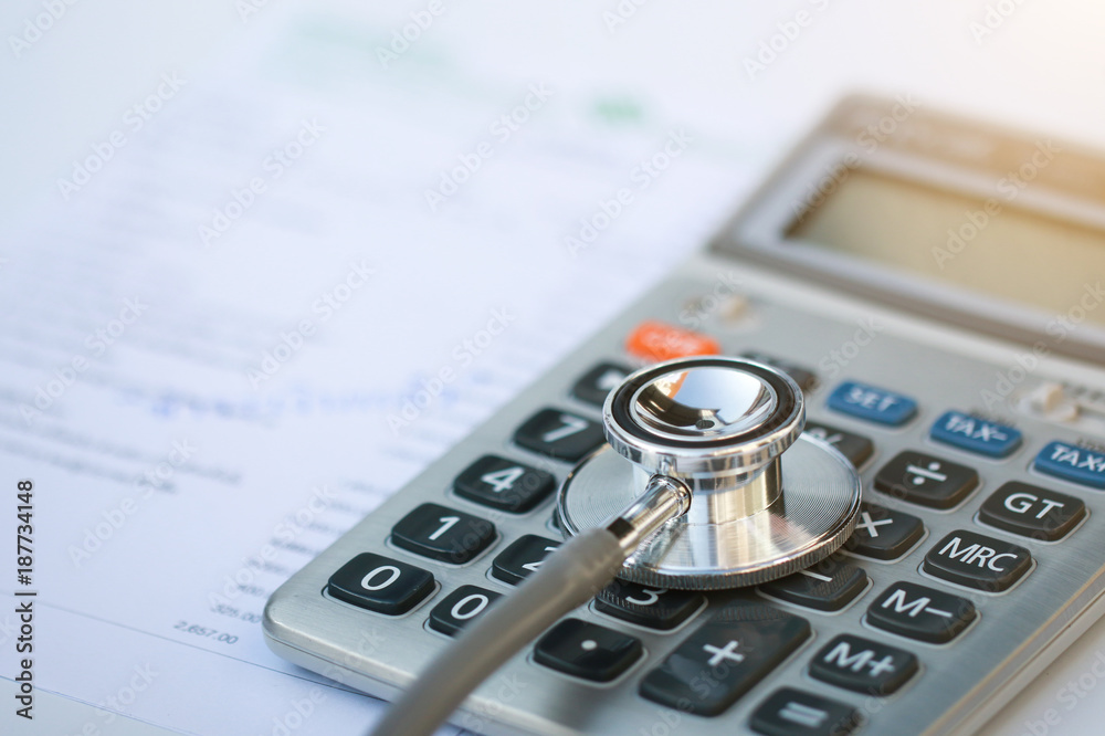 stethoscope and calculator on bills for finance plan or health insurance. stethoscope and calculator on bills for finance plan or health insurance.