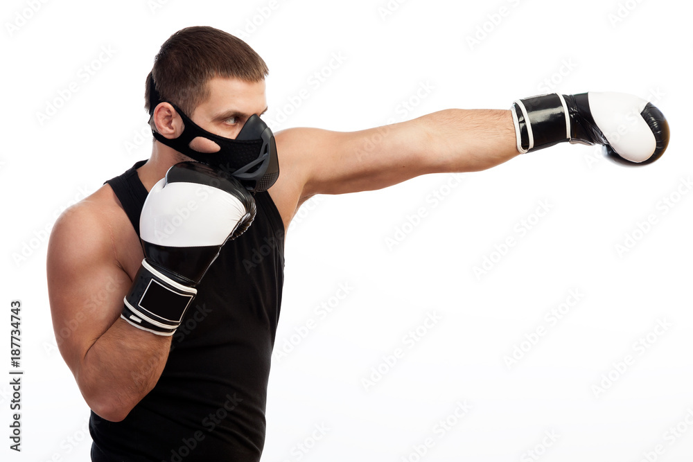 Young male athlete in a training mask, sports shirt and boxing gloves box on a white isolated background Young male athlete in a training mask, sports shirt and boxing gloves box on a white isolated background