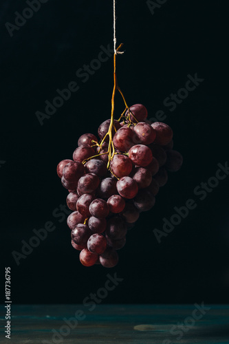 Obraz na płótnie Hanging fresh red grapes, vintage style. w salonie