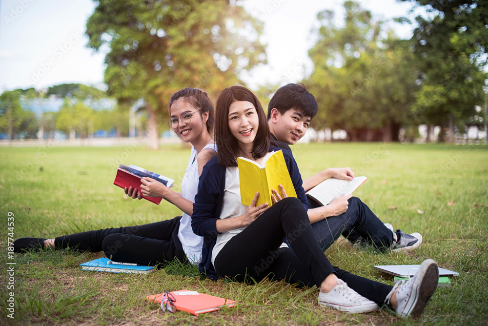 group of university student working on tutorial together after class in field of park of University group of university student working on tutorial together after class in field of park of University