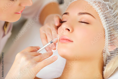 Woman receiving cosmetic injection on her face photo