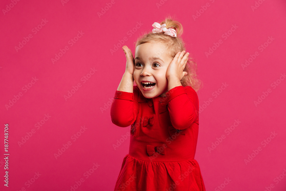 Surprised happy young girl in red dress holding her head Surprised happy young girl in red dress holding her head