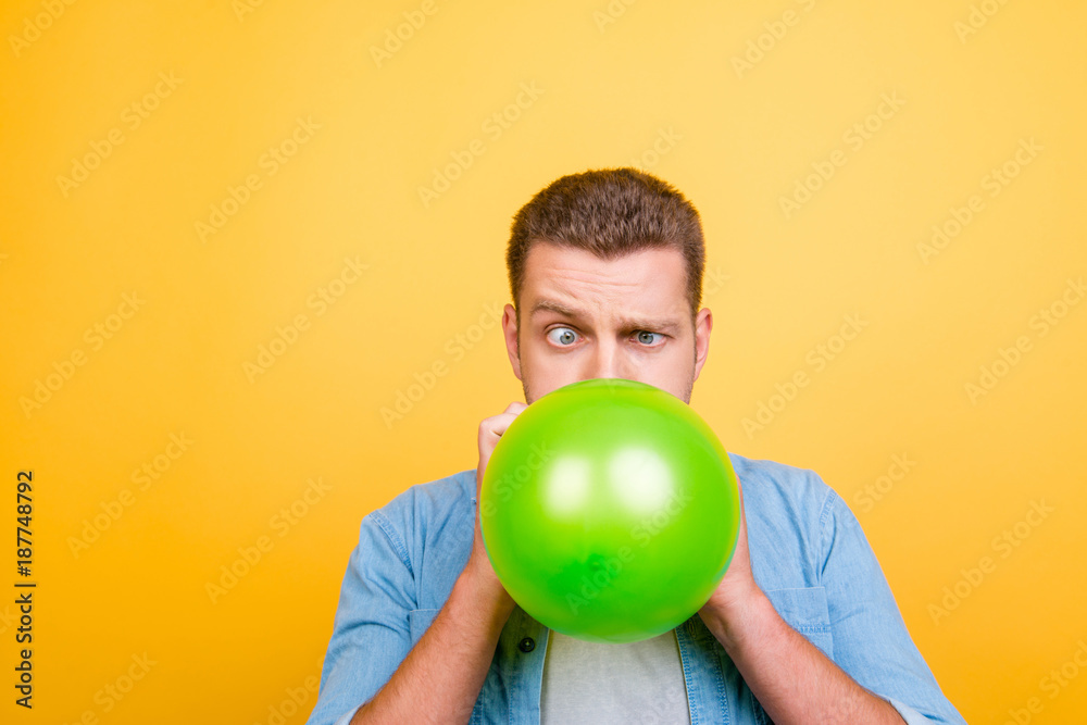 Young attractive blond man tired to blow up balloons new year party,  twisted eyes over yellow background Stock Photo | Adobe Stock