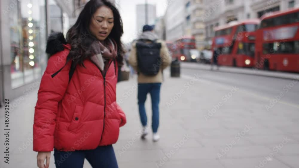 Young woman gets bumped in the street and drops her phone 