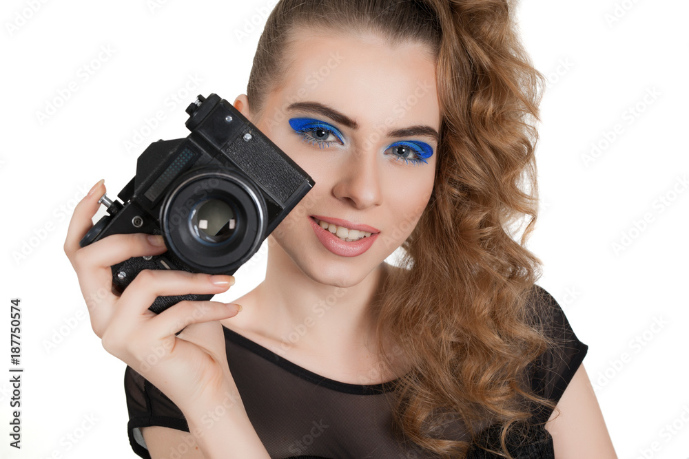 Young beautiful girl with makeup and haircut with a camera in her hand isolated on white background. Studio photography. Young beautiful girl with makeup and haircut with a camera in her hand isolated on white background. Studio photography.