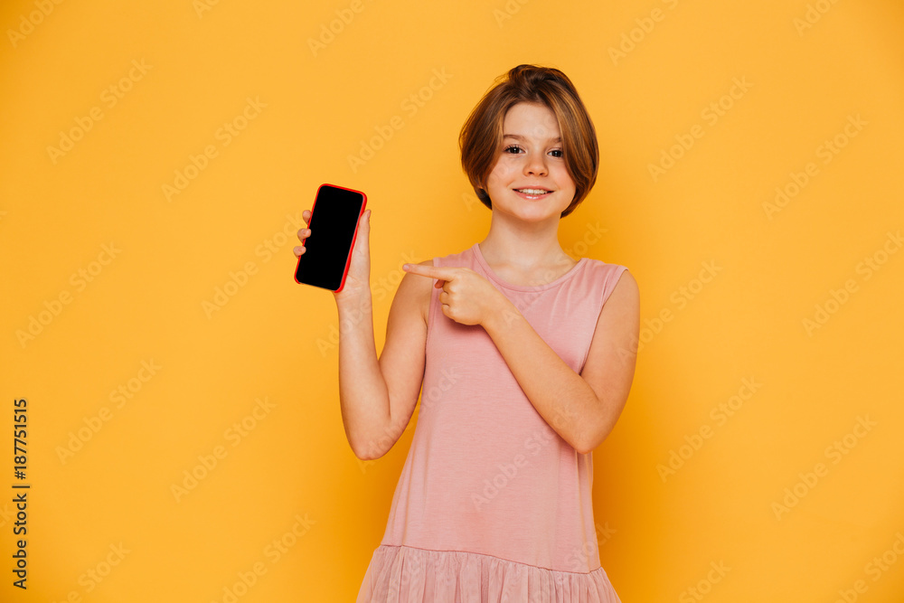 Smiling girl pointing at blank screen of smartphone isolated Smiling girl pointing at blank screen of smartphone isolated