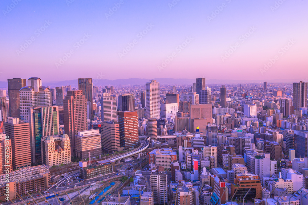 Obraz premium High-rise buildings in the middle of Osaka with spectacular sunset colors. Umeda district aerial view. Osaka cityscape, Japan.
