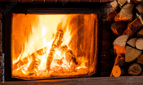 Wooden table top and burning warm fire at the background.