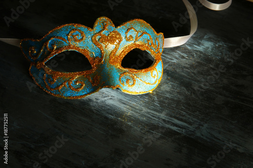 Image of elegant blue and gold venetian, mardi gras mask over black background.